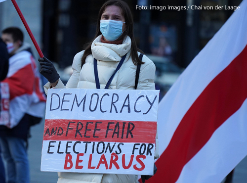 Eine Frau hält bei einer Demonstration in Köln ein Schild in die Höhe. Darauf fordert sie Demokratie und freie Wahlen für Belarus.