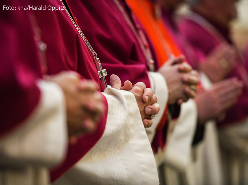 Bischöfe haben die Hände zum Gebet gefaltet.