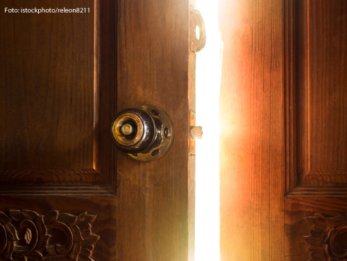 Durch einen Türspalt fällt helles Licht. 