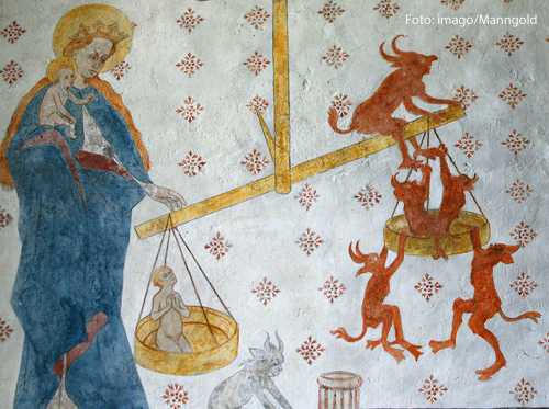 Eine Wandmalerei in einer Kirche zeigt das jüngste Gericht. 