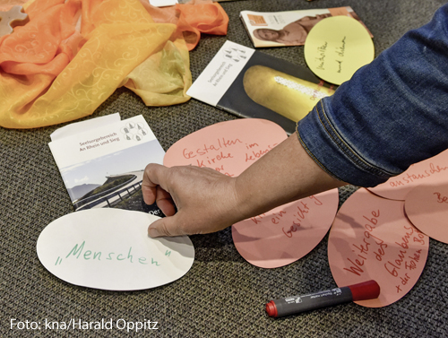 Ein Mann legt einen beschriebenen Zettel auf den Boden. 