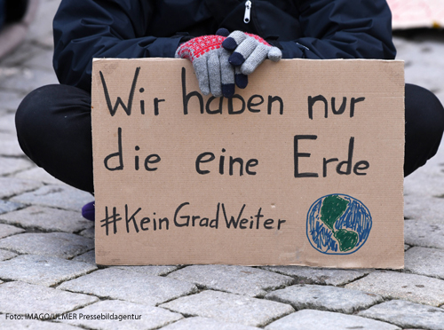Ein Demonstrant mit dem Plakat: Wir haben nur eine Erde!