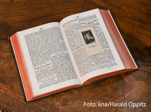 Ein Stundenbuch liegt aufgeschlagen auf einem Tisch. 