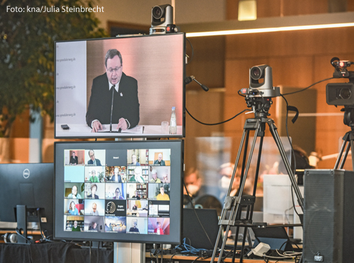 Bischof Georg Bätzing, Vorsitzender der Deutschen Bischofskonferenz (DBK), ist auf einem Monitor abgebildet im Regiezentrum der Online-Konferenz des Synodalen Weges am 4. Februar 2021 im Foyer der DBK in Bonn. Darunter ein Bildschirm mit Teilnehmern der Konferenz.