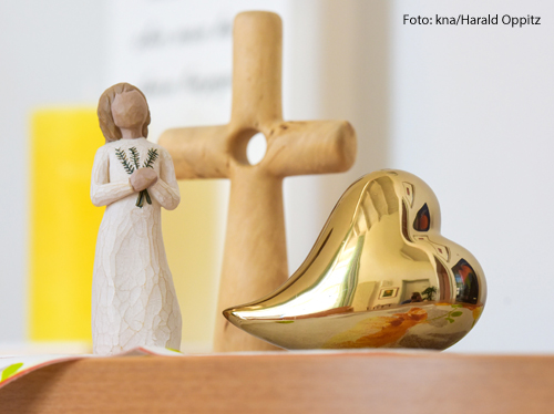 Die Figur eines Engels steht auf einem Nachtkästchen.