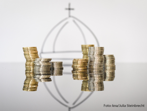 Geldmünzen vor einer Kuppel des Petersdoms symbolisieren die Finanzen des Vatikans.