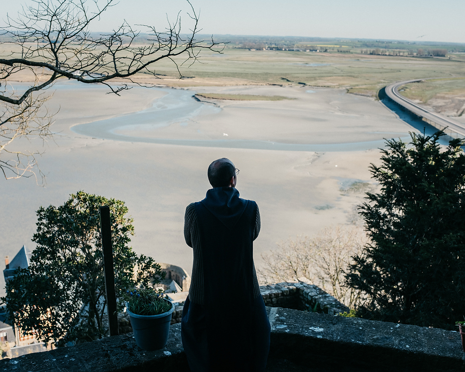 Mönch blickt auf die Landschaft am Mont Saint-Michel in der Normandie
