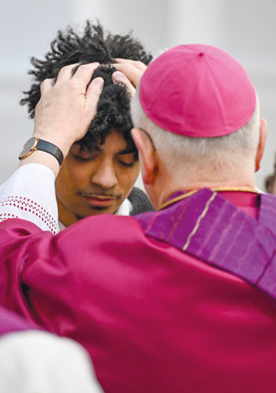 ein junger Mann wird gesegnet