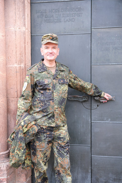 der katholische Militärpfarrer Christian Bock steht in Uniform vor einer Kirchentür