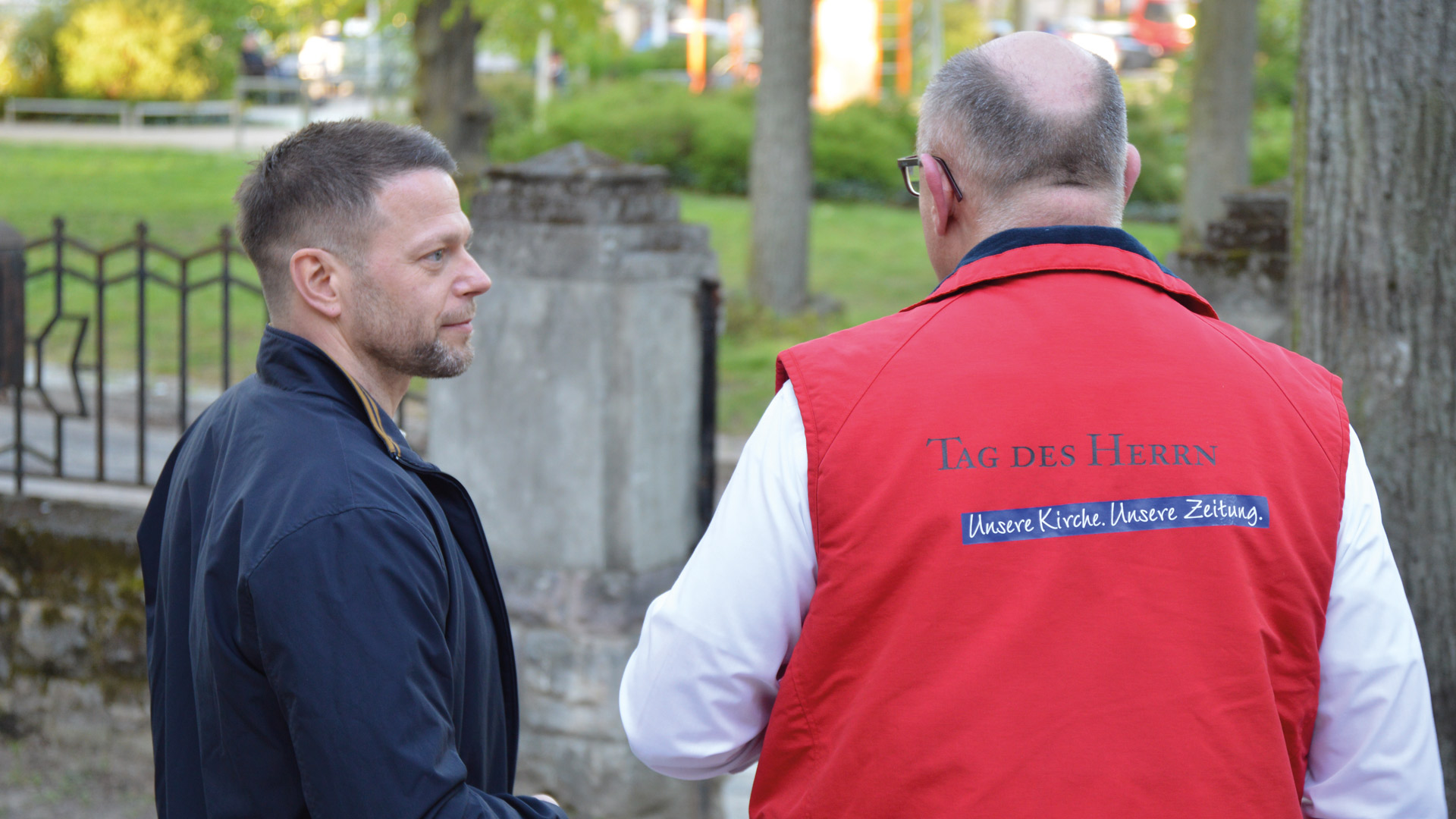 Willi Krug im Gespräch mit einem Mann vor einer Kirche