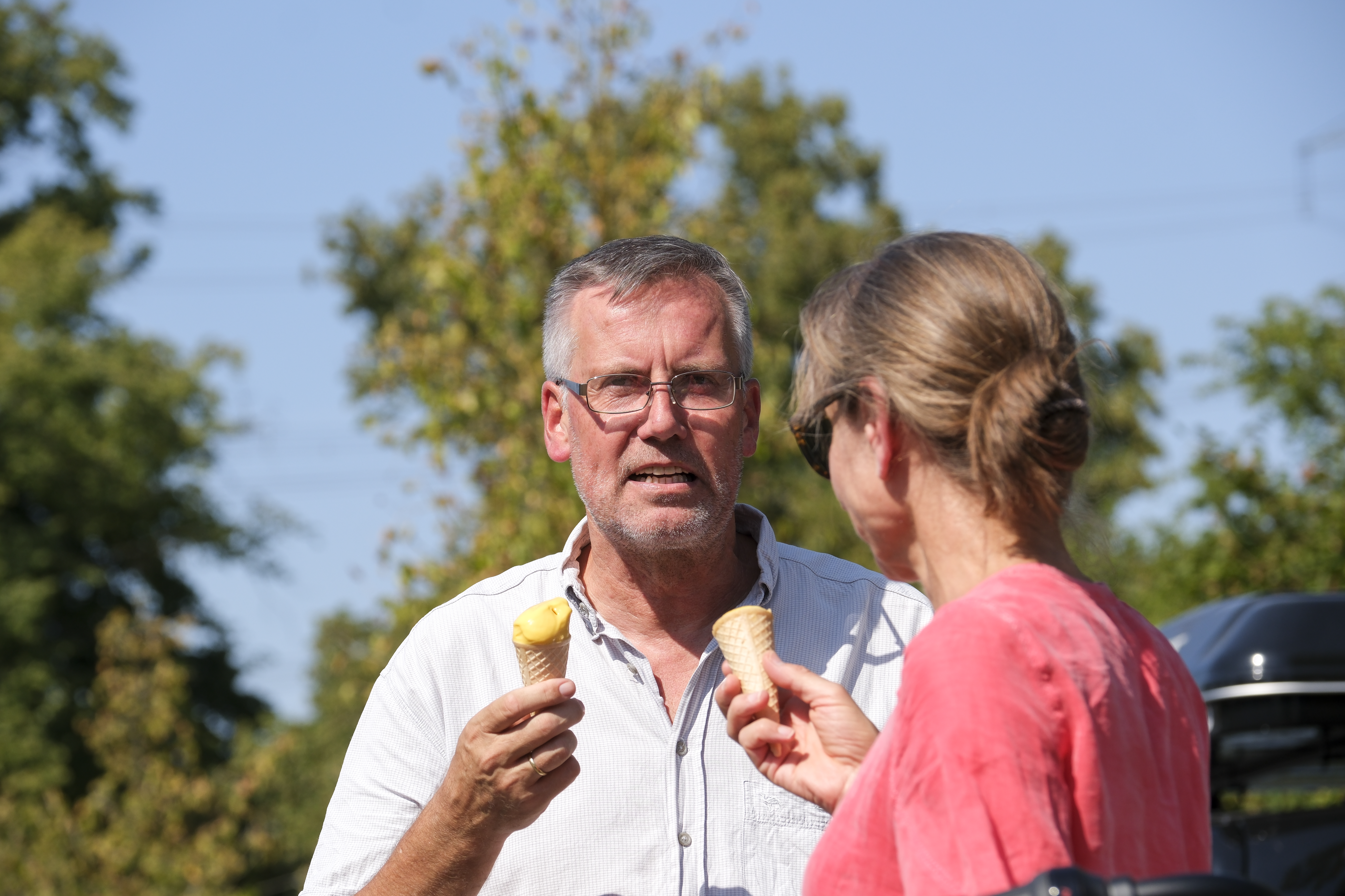 Ein Mann mit einem Eis im Gespräch mit einer Frau