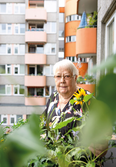 eine alte Frau steht auf einem Balkon