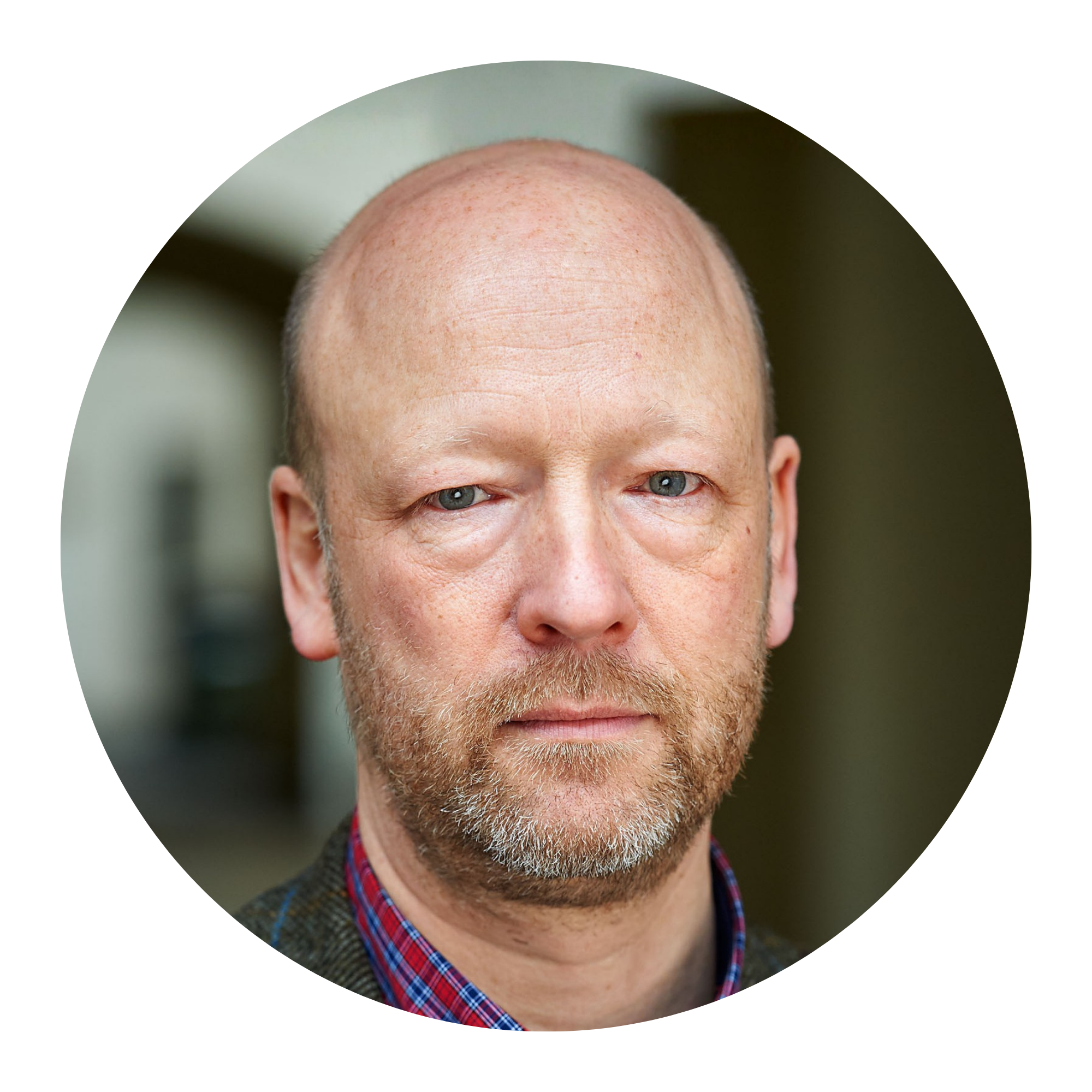 Ein glatzköpfiger Mann schaut in die Kamera