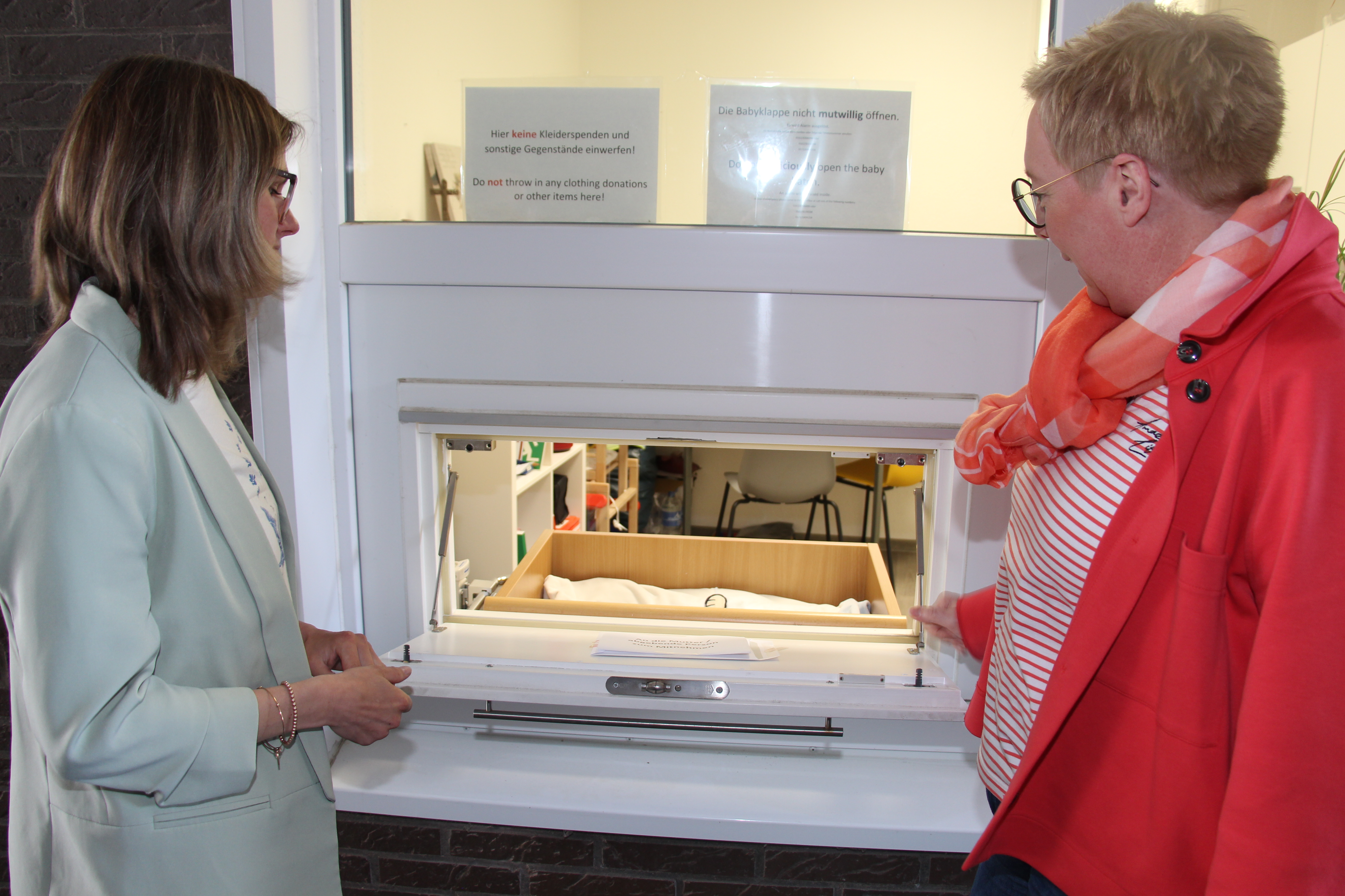 zwei Frauen bei der Babyklappe