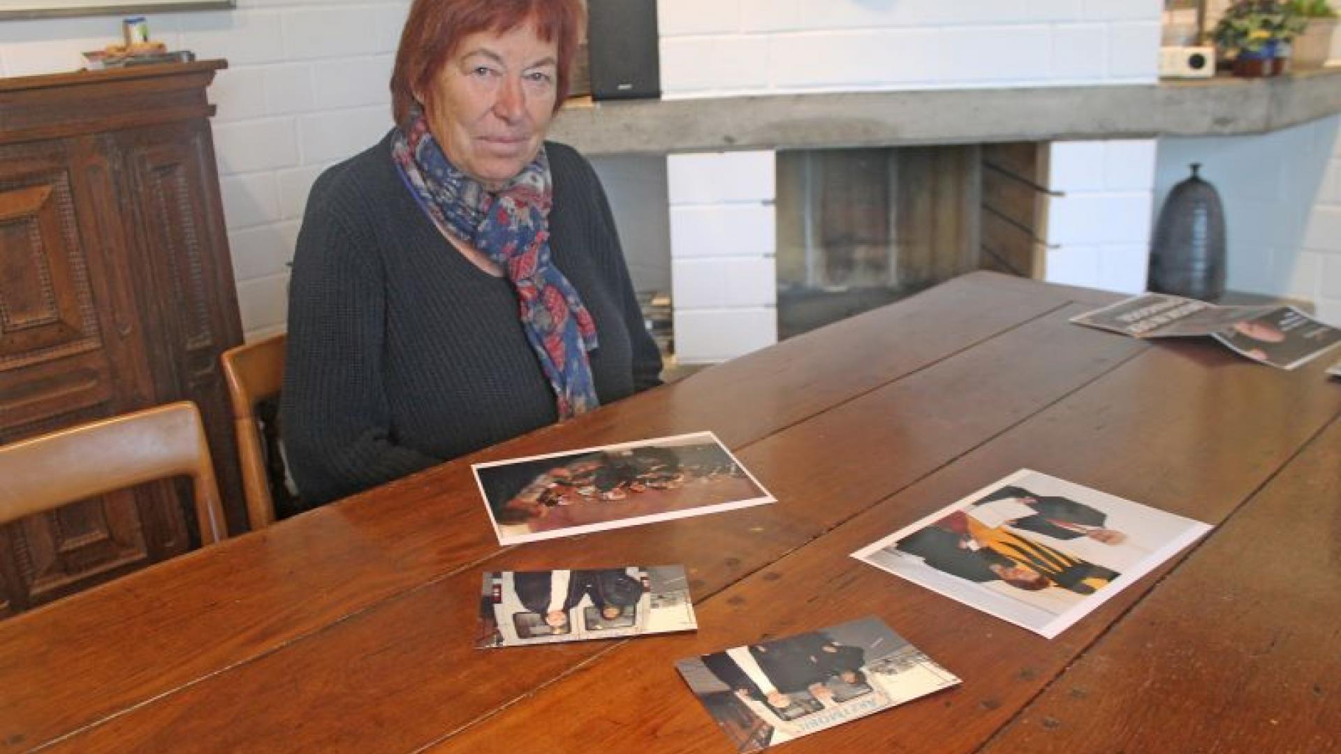 Monika Orth sitzt vor einem Tisch mit alten Fotos