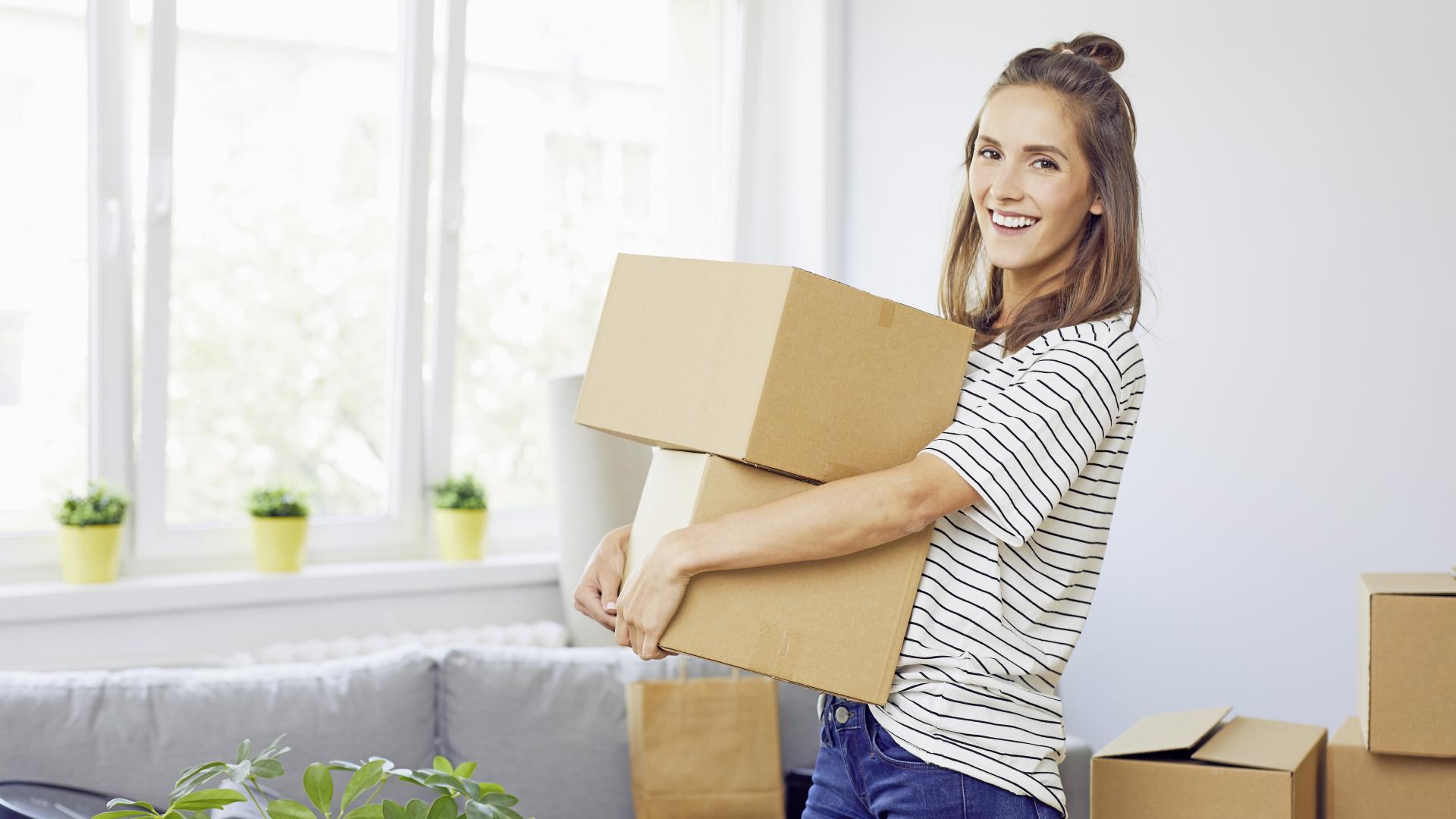 Junge Frau trägt Umzugskisten