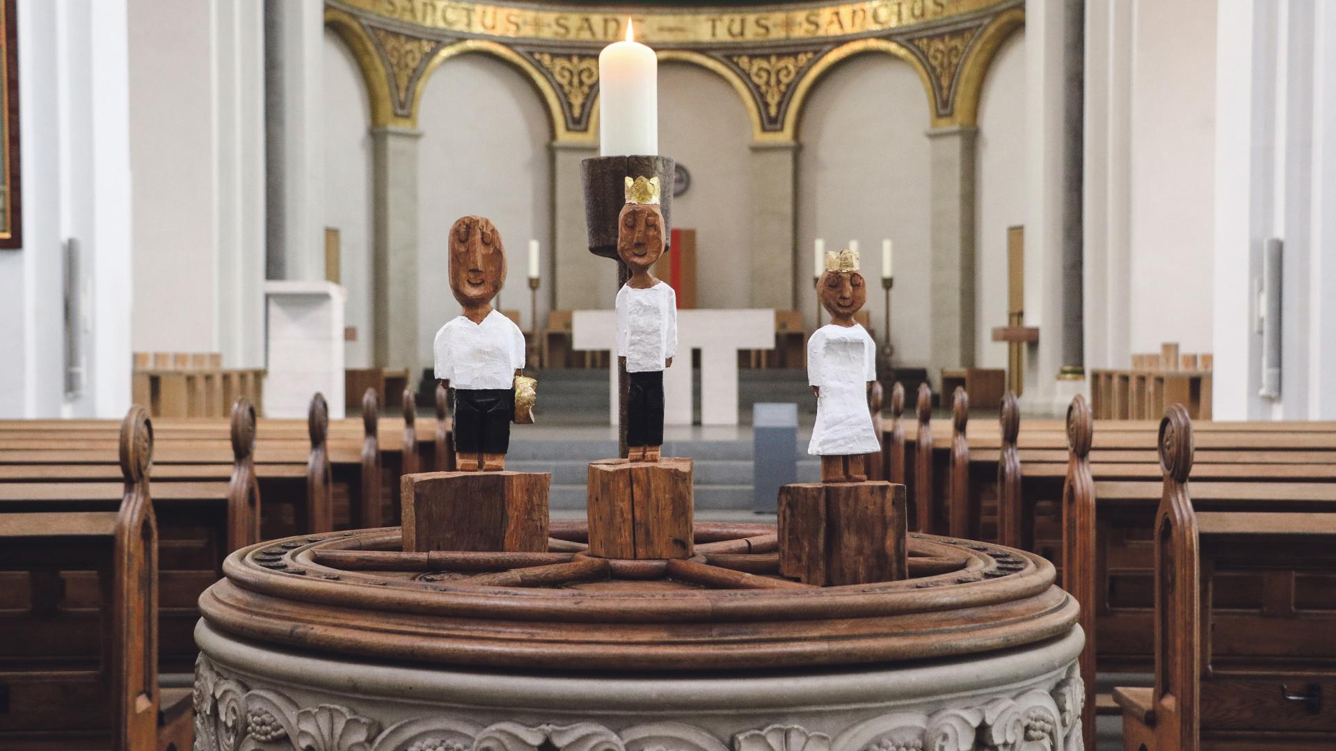 Holzskulpturen von Ralf Knoblauch präsentiert auf dem Taufbecken im St. Marien-Dom.