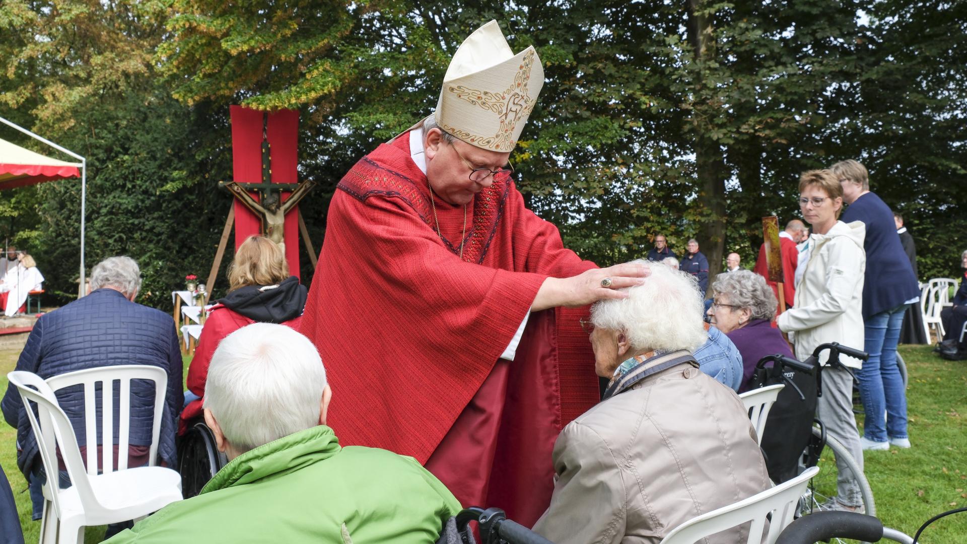 Altbischof Bode spendet einer Pilgerin den persönlichen Segen.