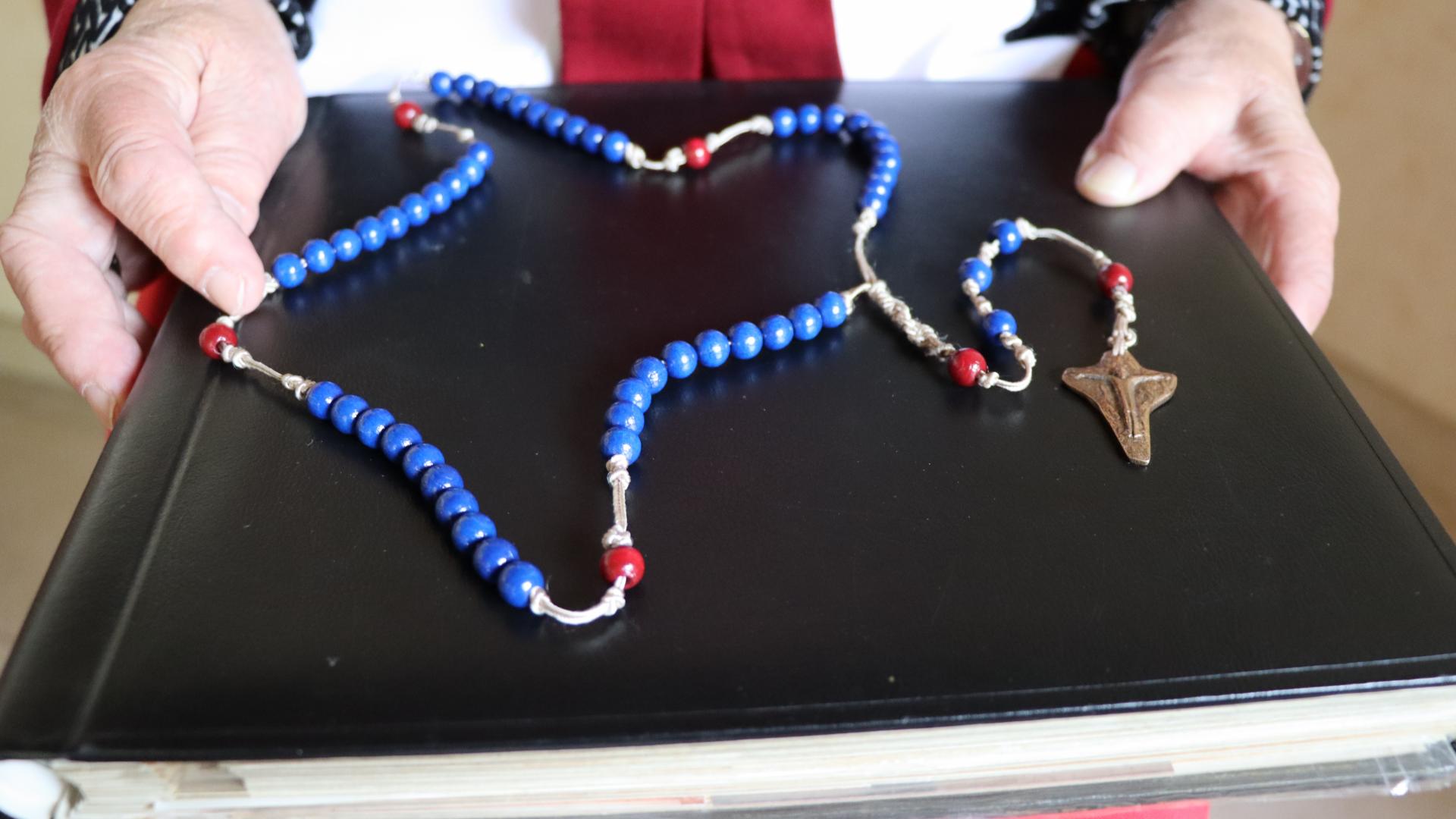 Eine Kette mit blauen und roten Perlen sowie mit einem Kreuz