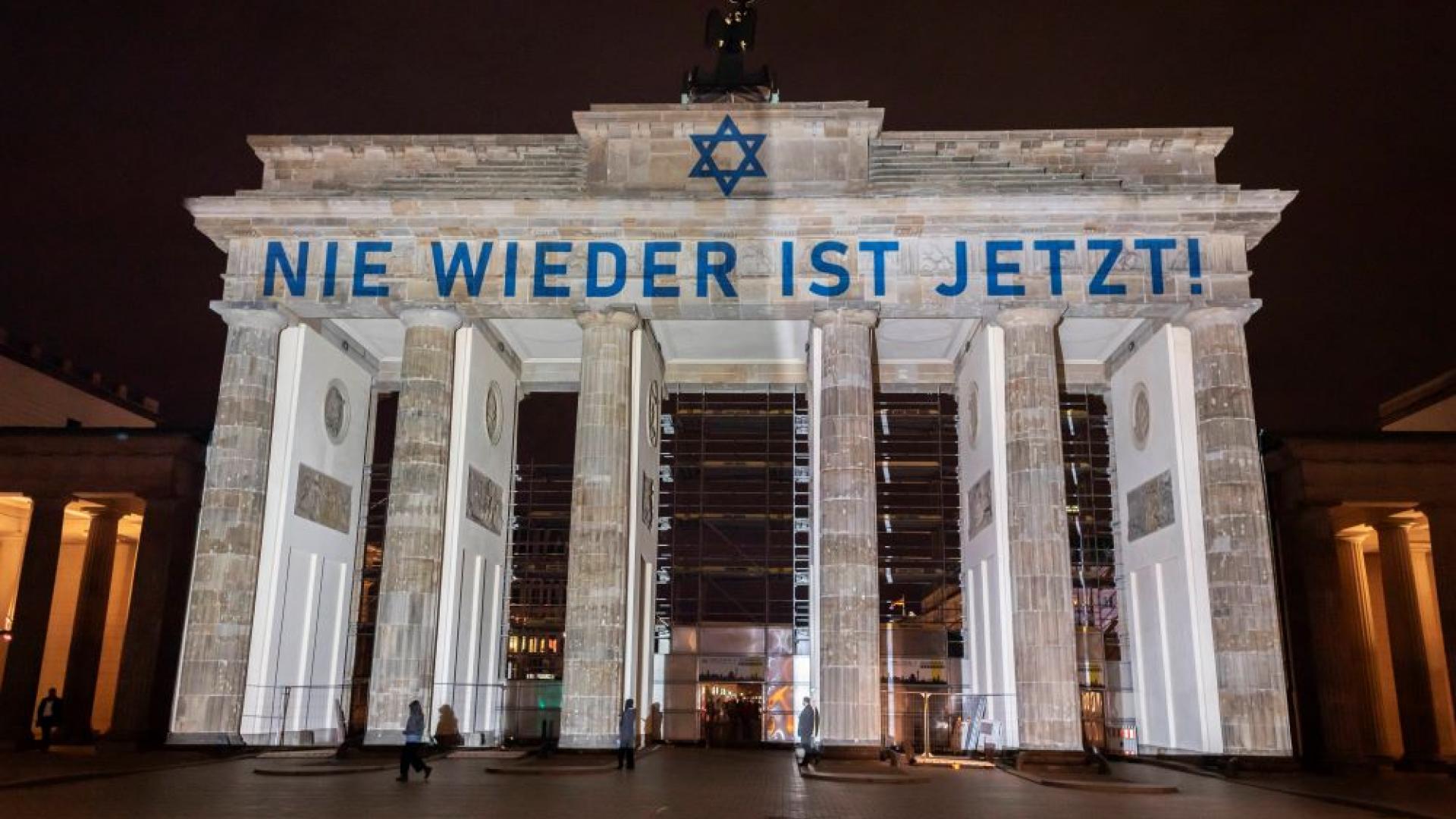Auf dem Brandenburger Tor sind der Schriftzug „Nie wieder ist jetzt!“ und der Davidstern zu sehen.