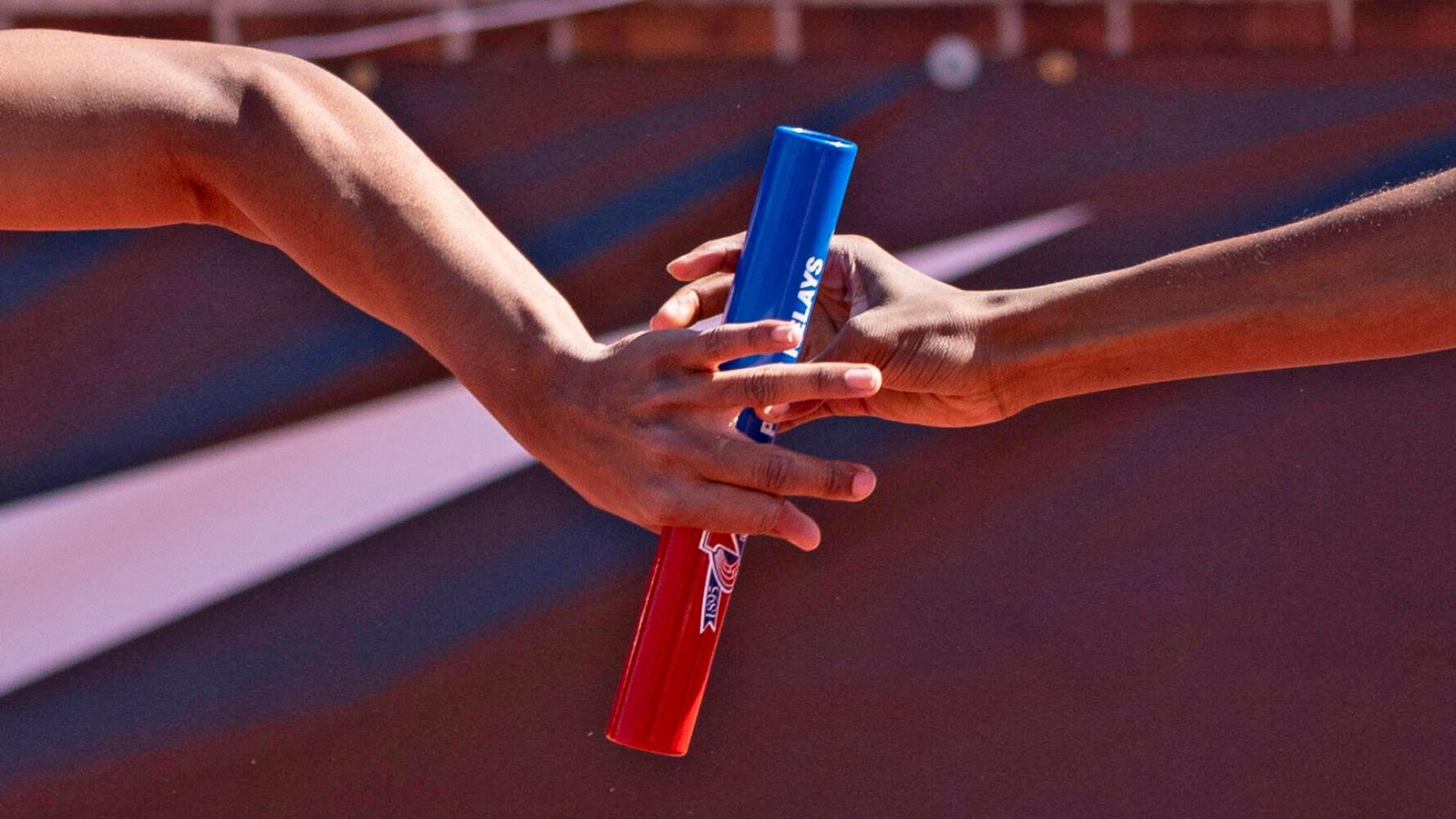 Eine Hand reicht einen Staffelstab weiter