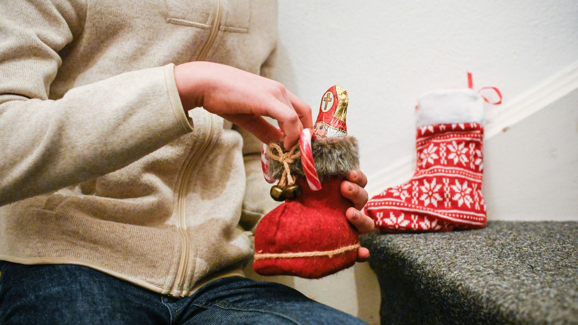 Ein Kind packt seinen gefüllten Nikolausstiefel aus