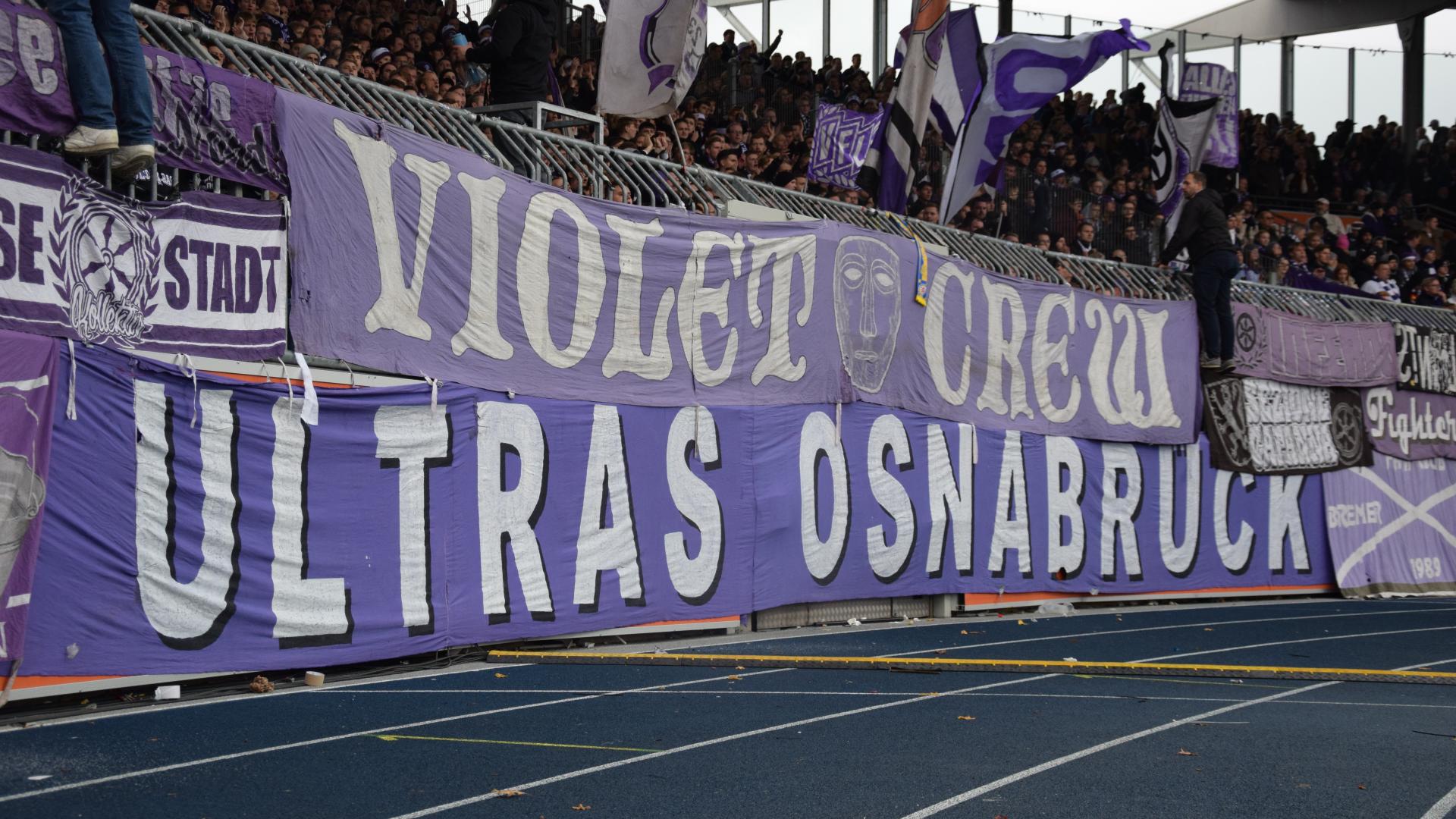 Ein Banner mit der Aufschrift Violetcrew hängt an einem Zaun im Stadion