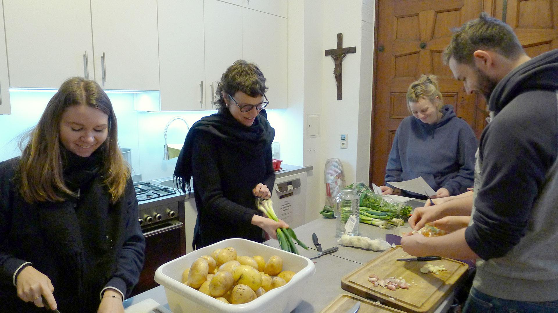 Junge Menschen von der Berliner young Caritas kochen.