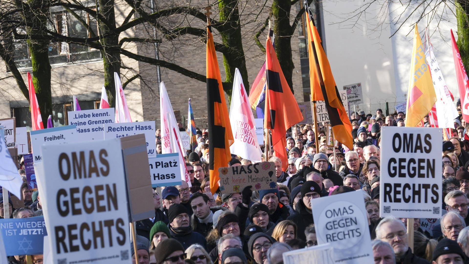 Viele Menschen stehen in einer Gruppe und Demonstrieren. Einige halten Plakate hoch, zum Beispiel "Omas gegen rechts".