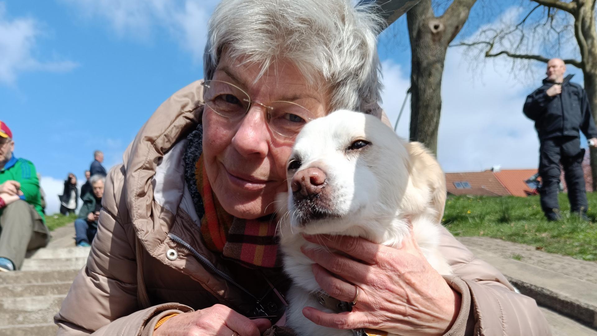 Ein ältere Dame kuschelt mit ihrem Hund
