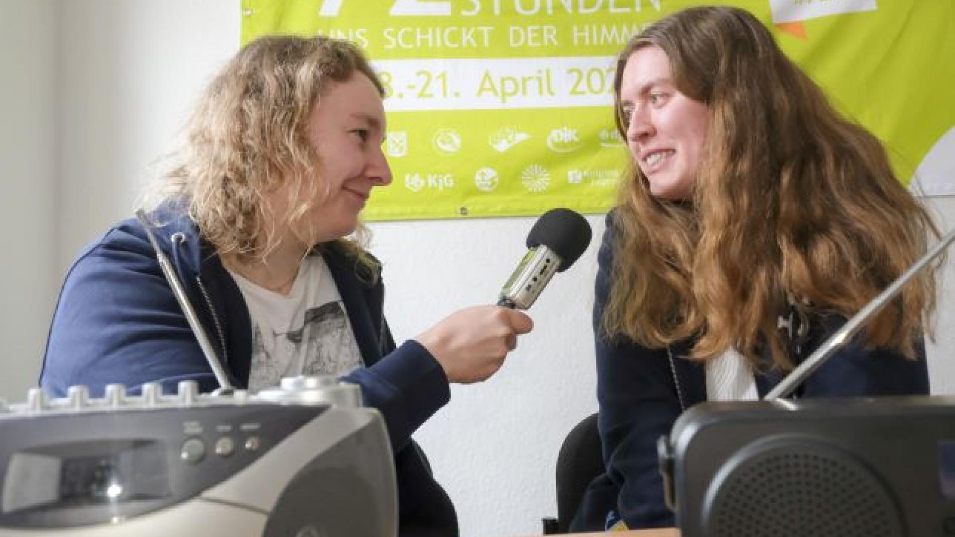 Zwei Frauen mit einem Mikrophon am Radio.