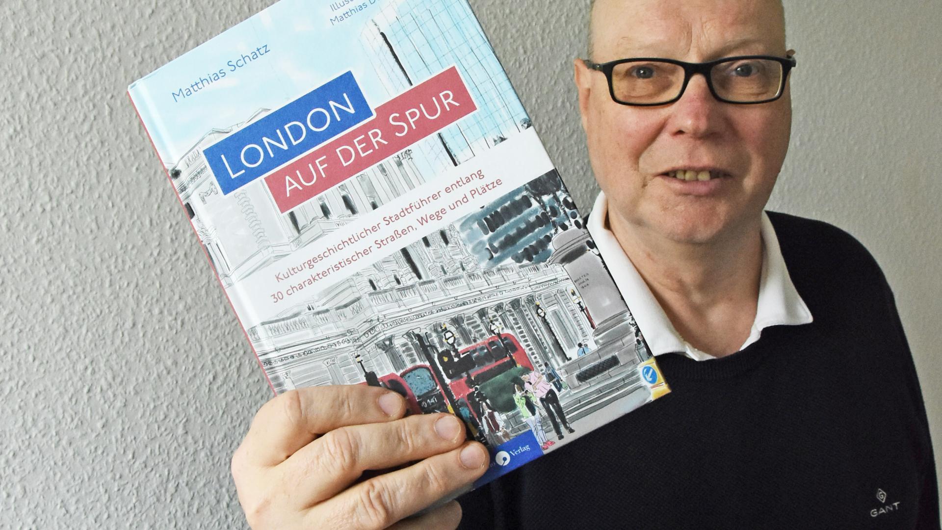 Ein Mann hält ein Buch in die Kamera