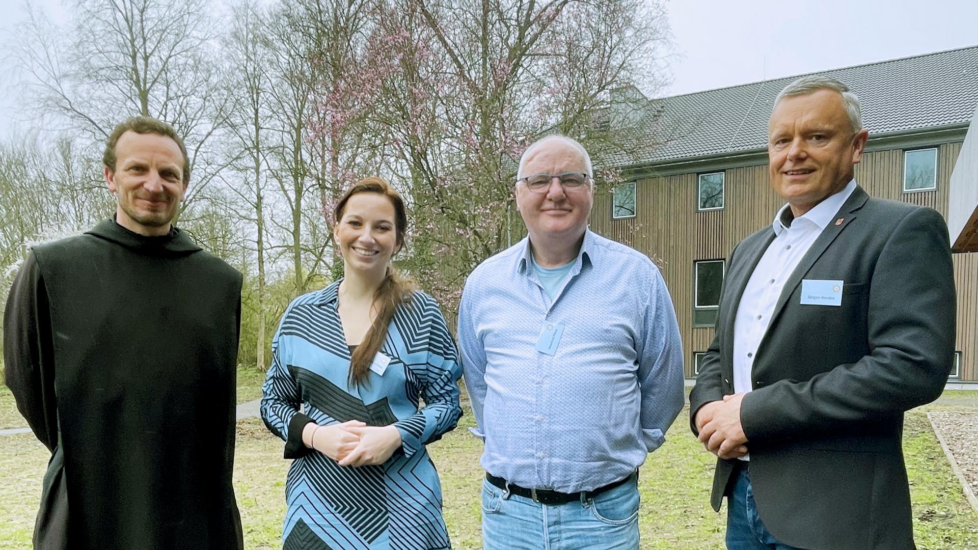 Vier Personen blicken in die Kamera