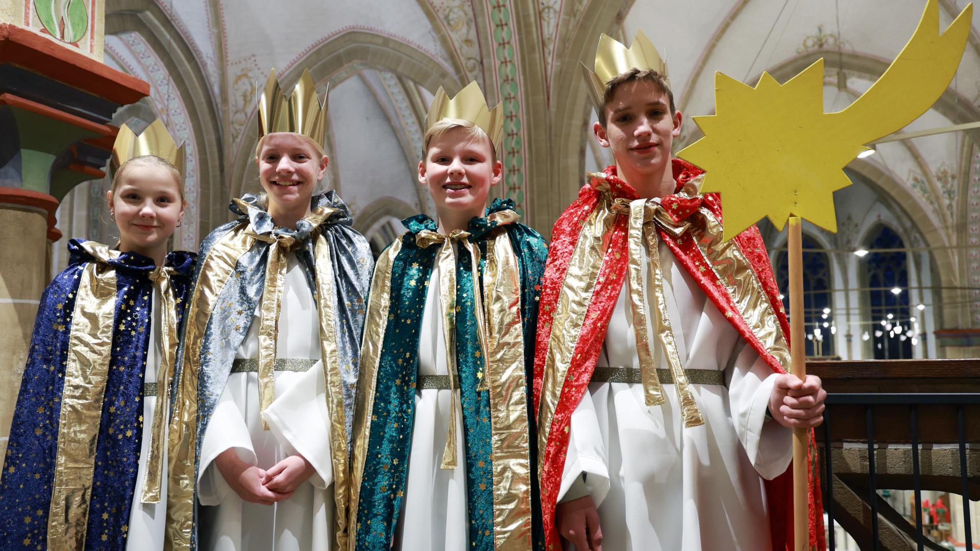 Vier Kinder in bunten Kostümen der Sternsinger