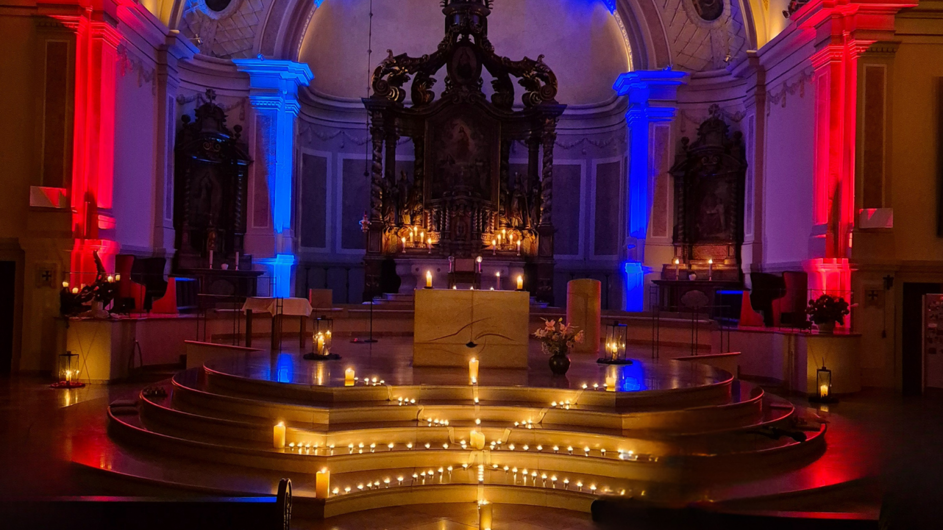 Ein Kirchenaltar ist rot und blau beleuchtet.