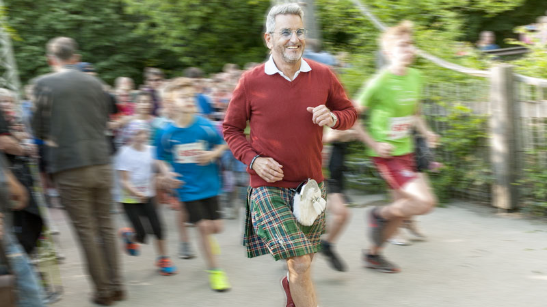 Ein Mann joggt und schaut lachend in die Kamera
