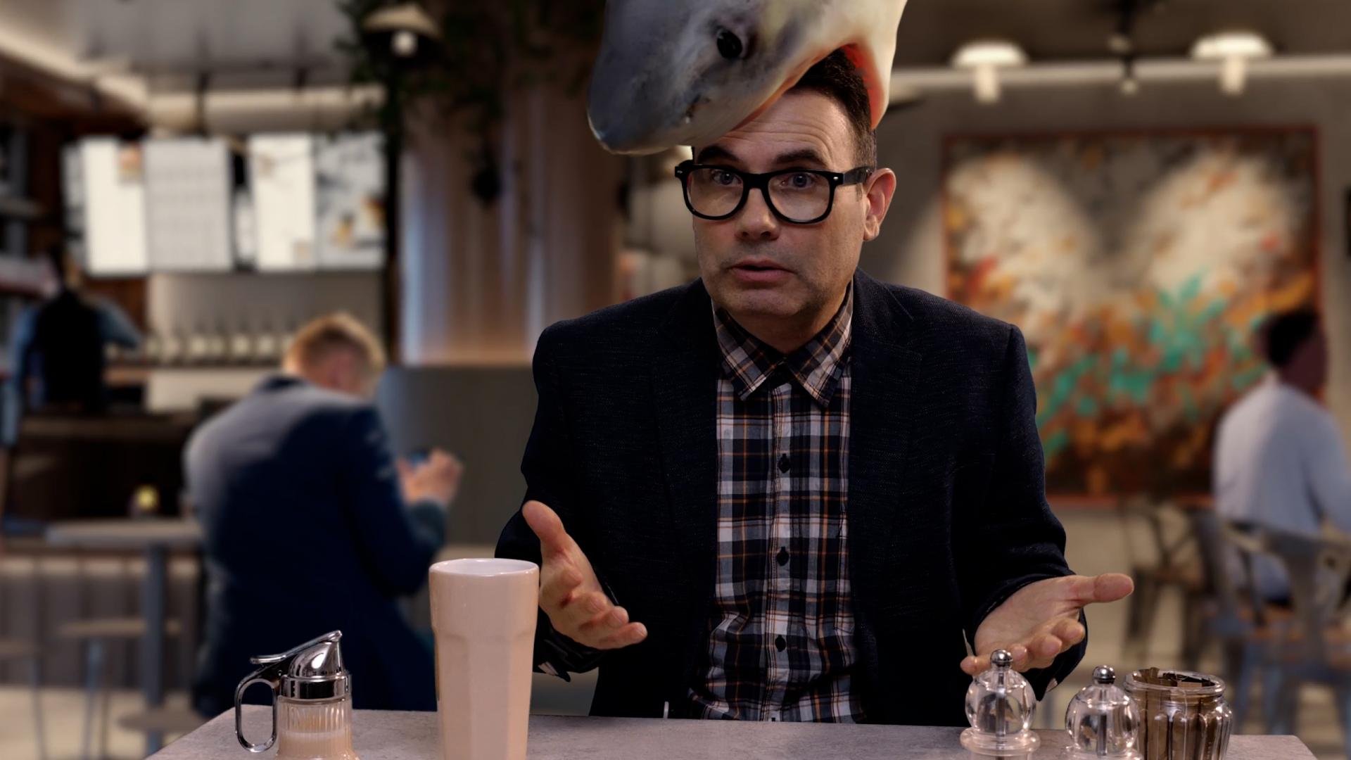 Ein Mann mit Brille sitzt am Tisch