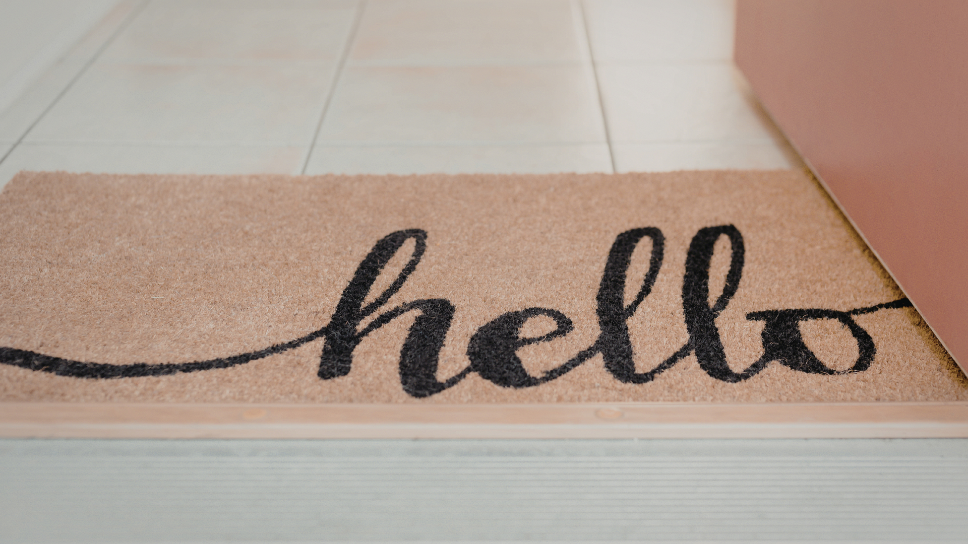 Fußmatte vor einer Haustür mit dem Schriftzug hello