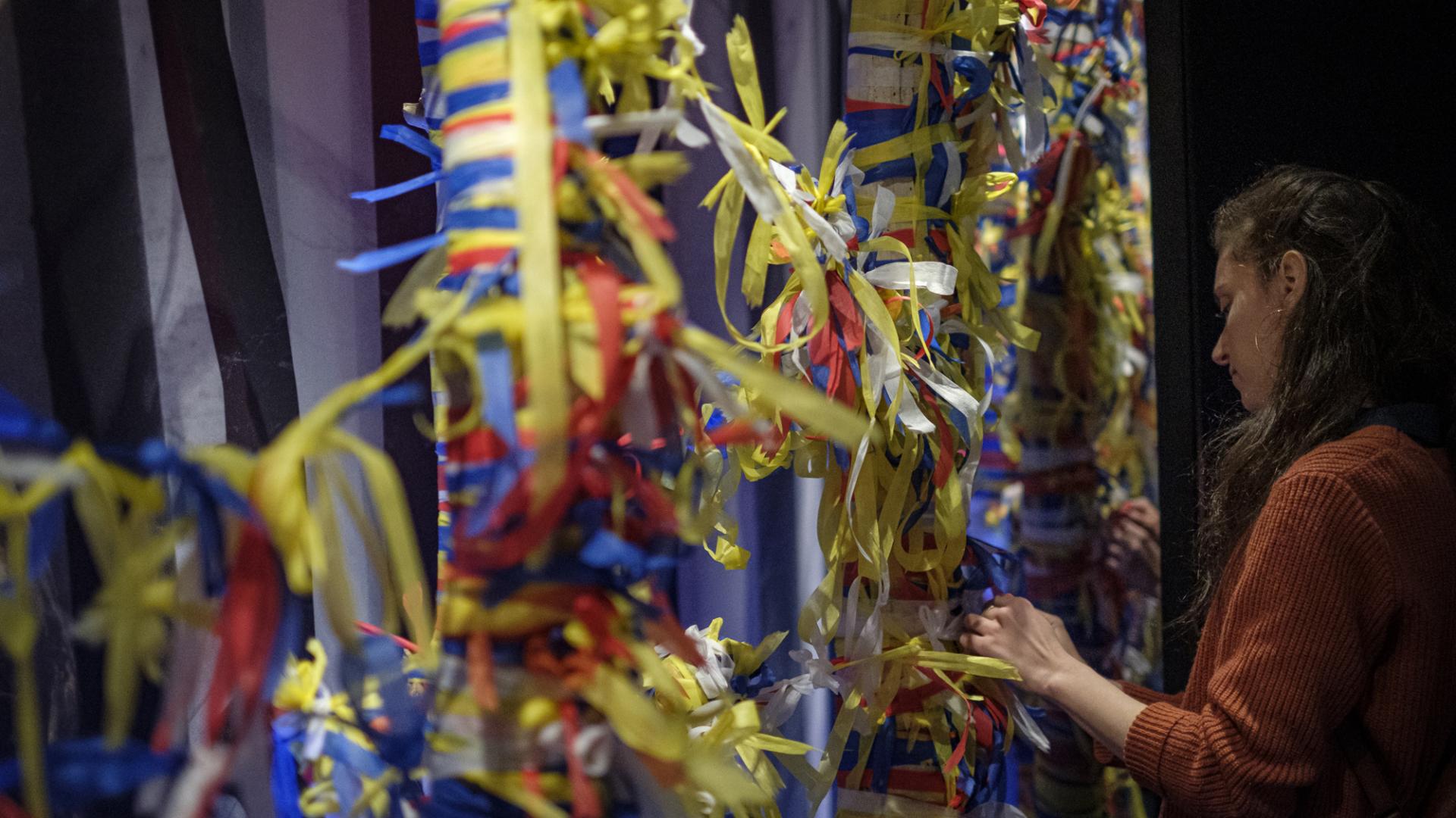 Eine Frau vor einem Baum mit vielen Zetteln