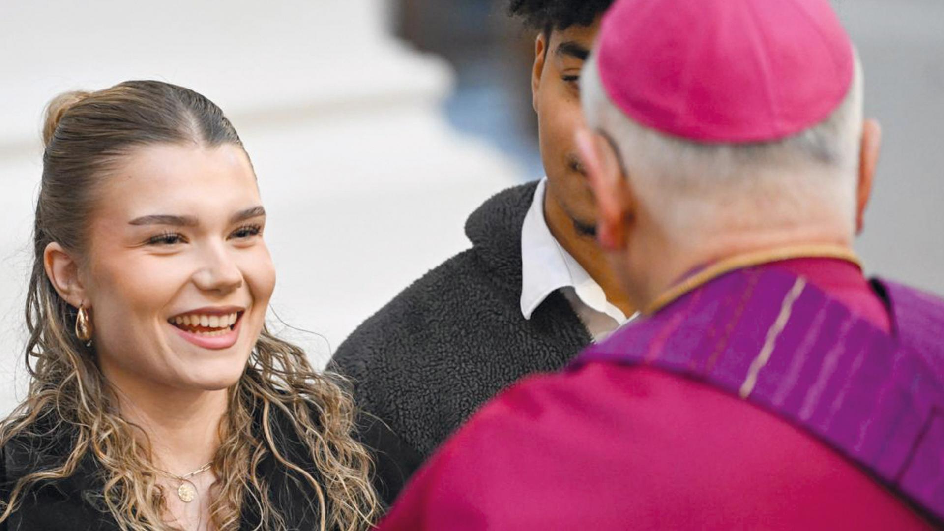 eine junge Frau schaut freudig Bischof Heinrich Timmerevers an