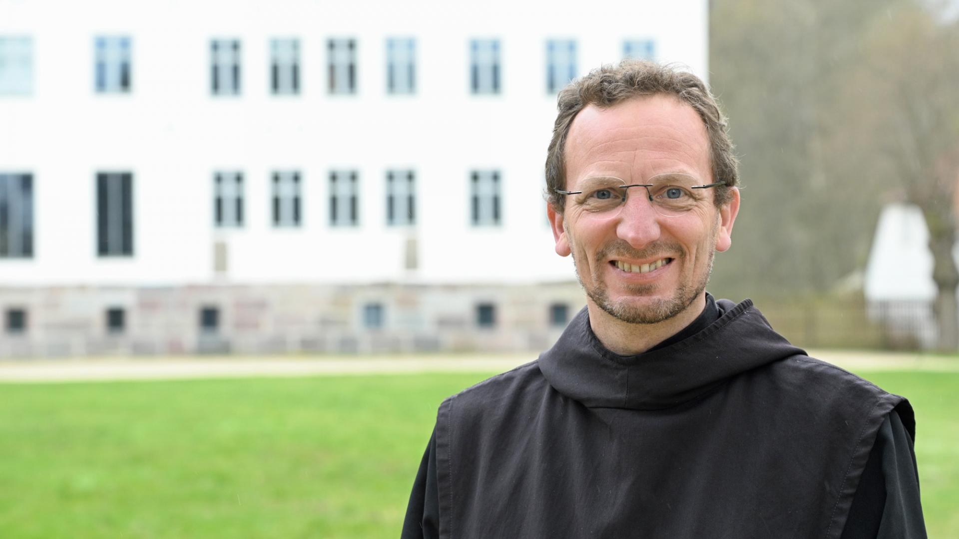 Ein Mann lächelt in die Kamera.