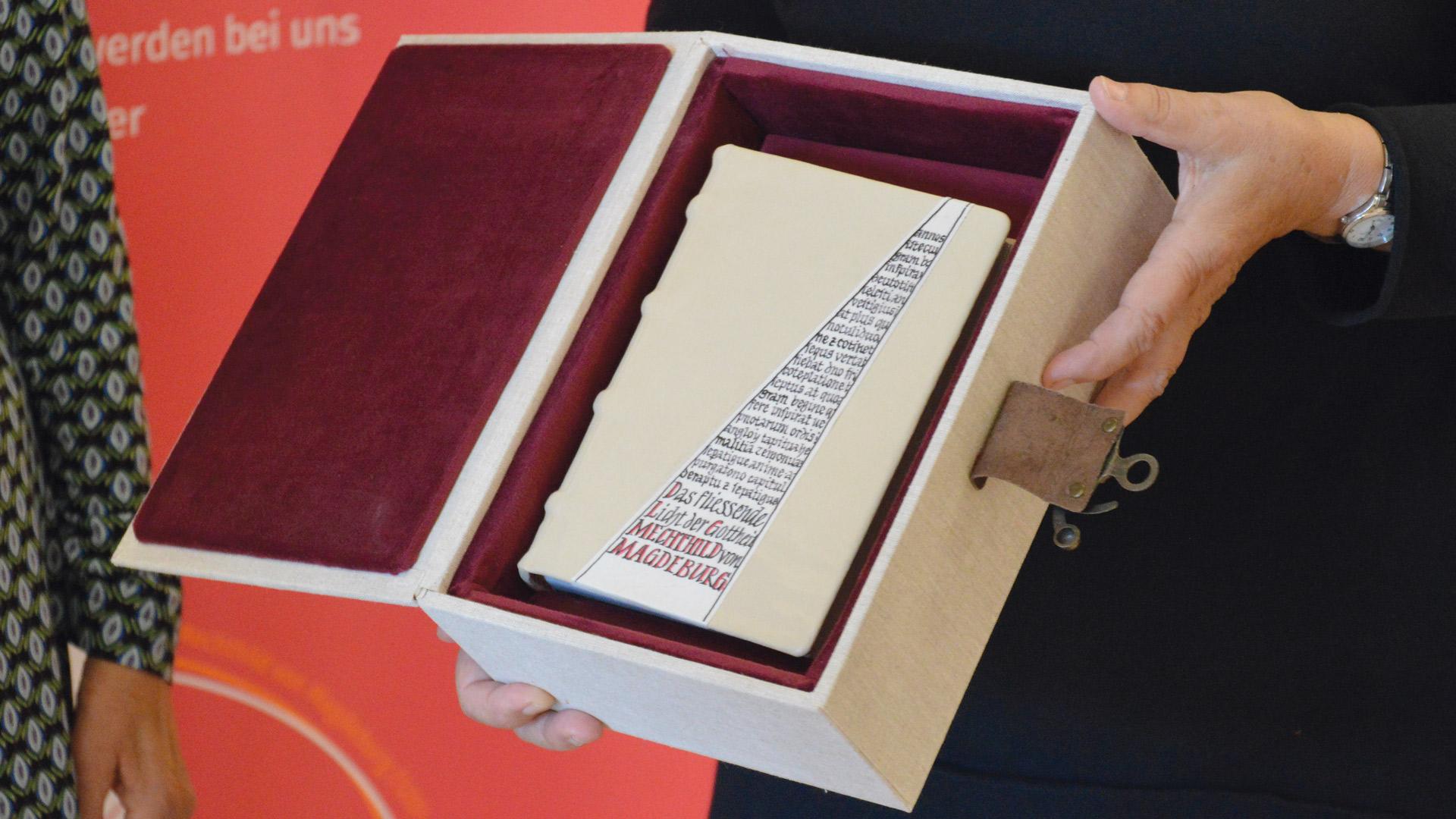 ein Buch liegt in einer Geschenkbox