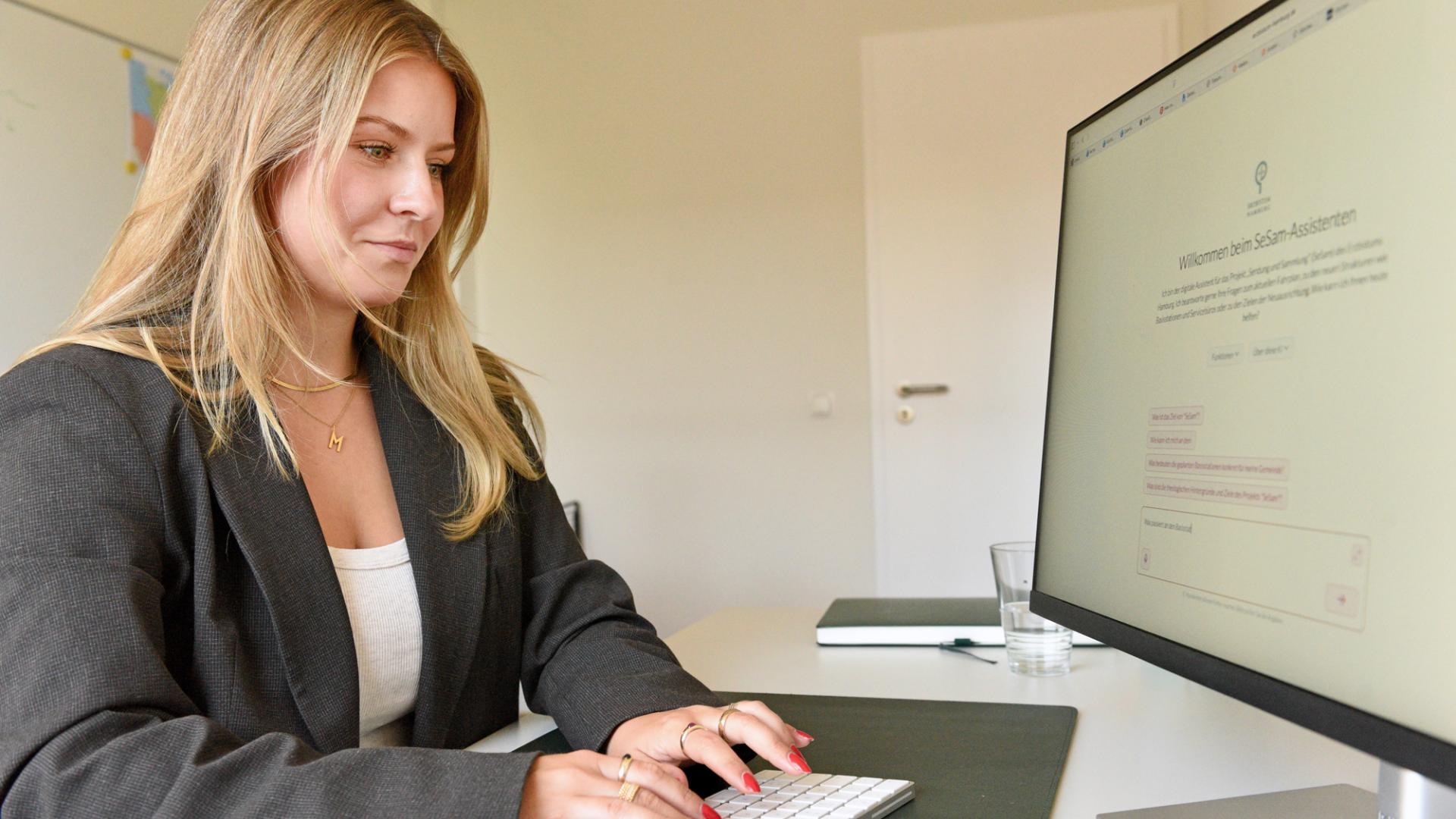 Eine Frau sitzt an einem Computer.