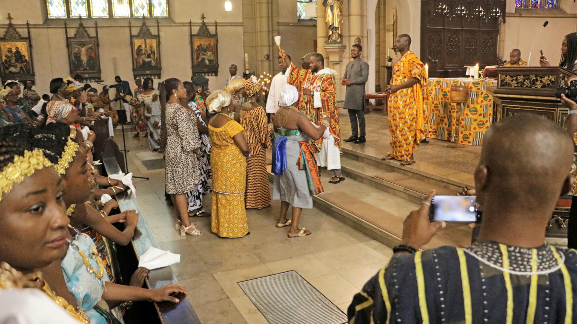 Frauen bringen Gegenstände zum Altar.