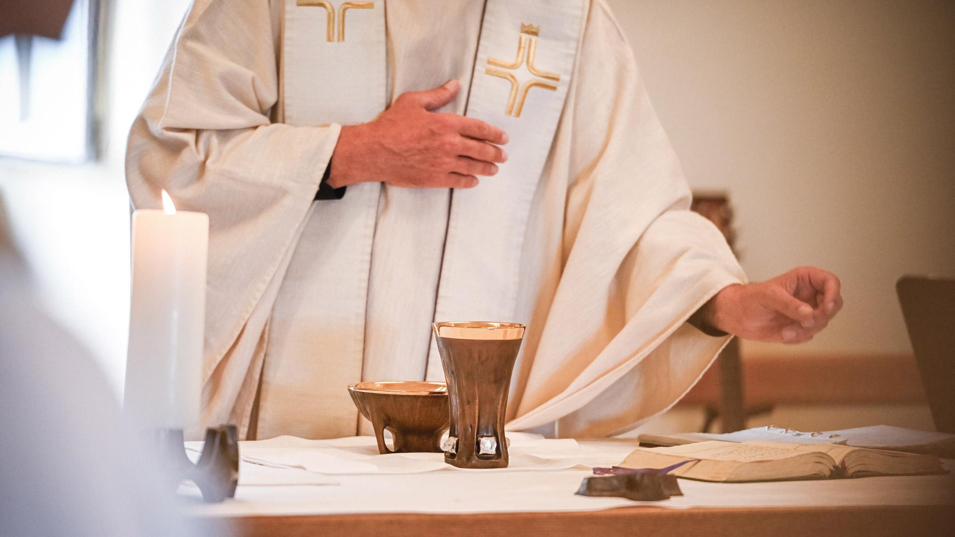 Priester während des katholischen Hochgebets am Altar