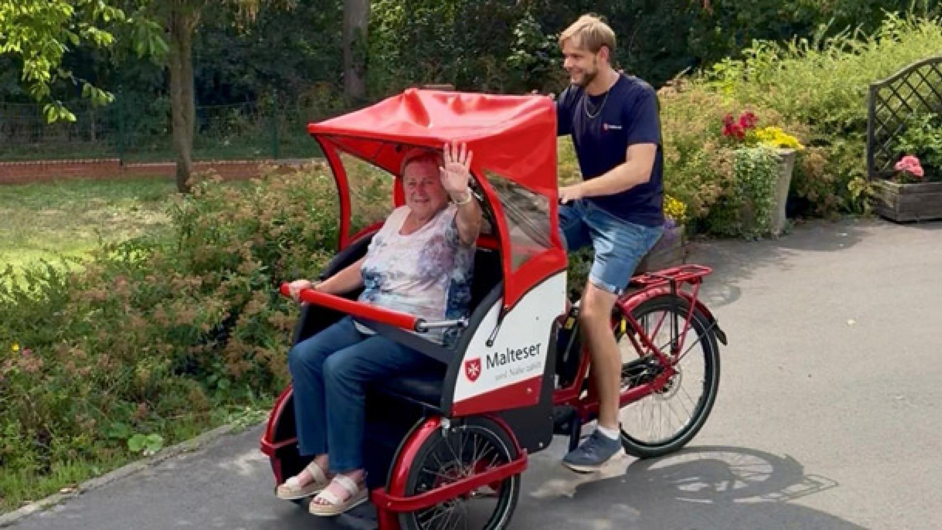eine ältere Frau lässt sich in einer Fahrradrikscha herumfahren