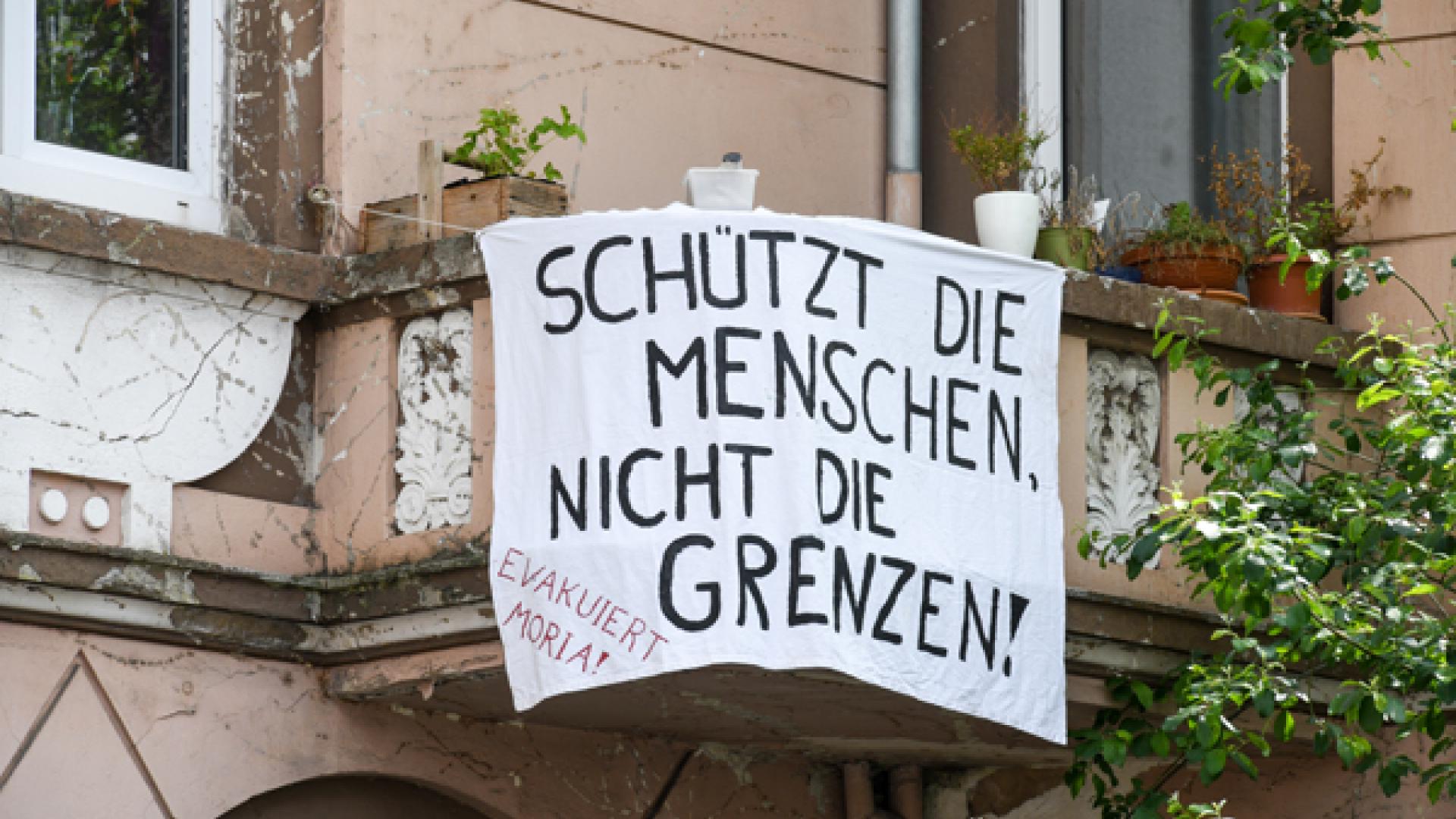 Ein Banner hängt an einer Hausfassade